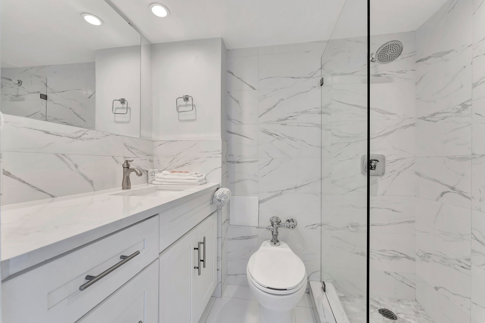 Luxurious bathroom with marble shower and glass divider