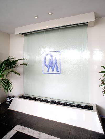 Ocean Manor lobby glass waterfall with OM logo