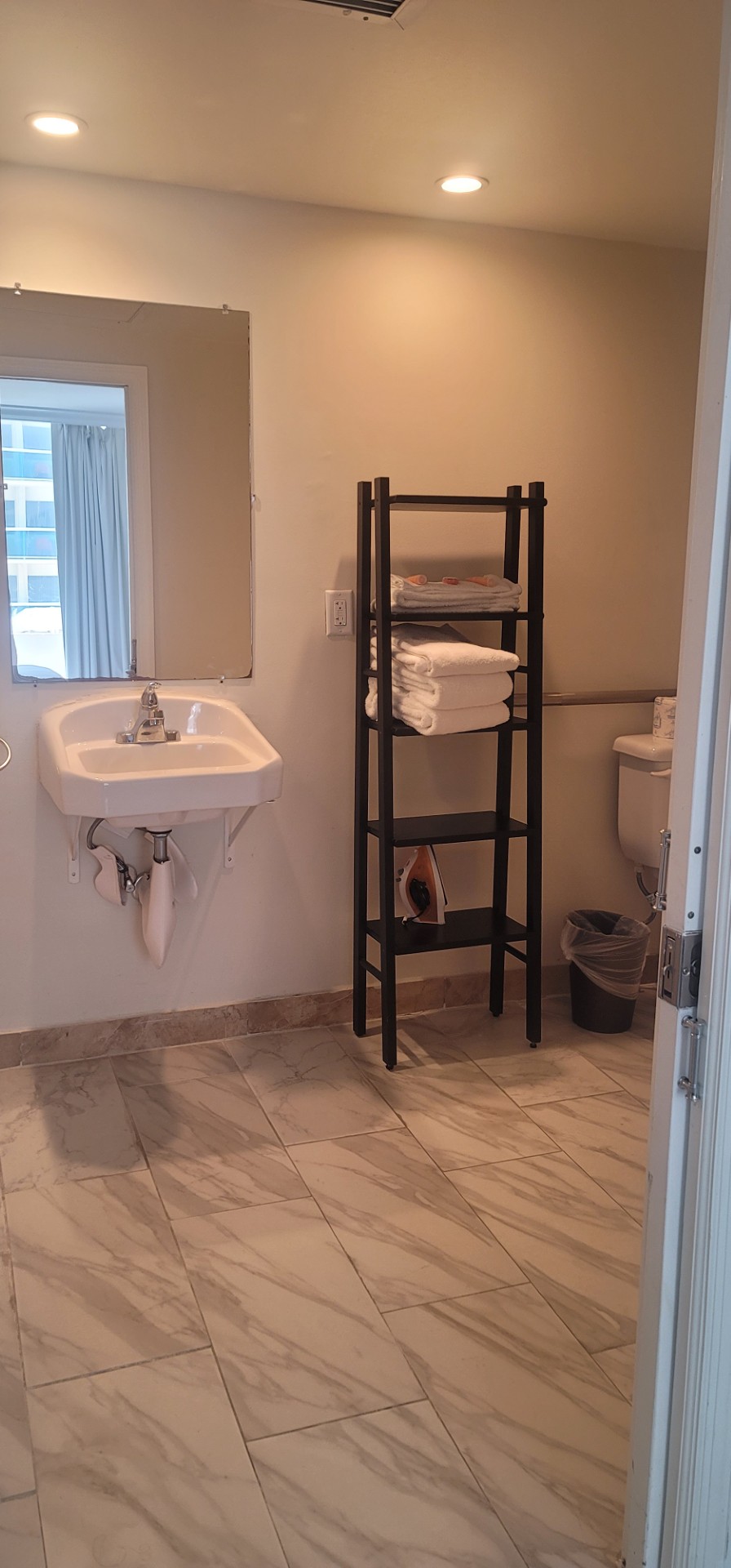 Bathroom mirror with sink and shelving in the guest room