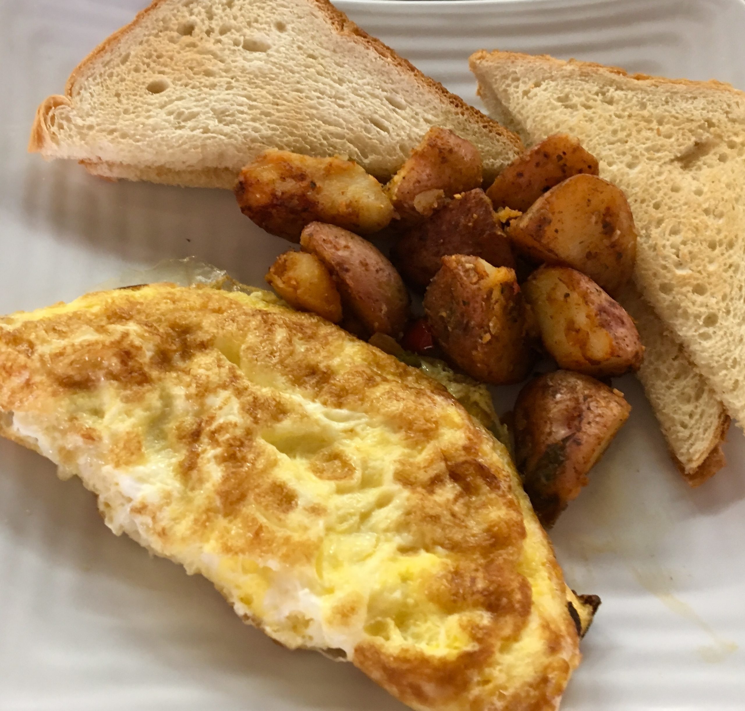 Bagel sandwich with eggs, cheese, bacon and potatoes