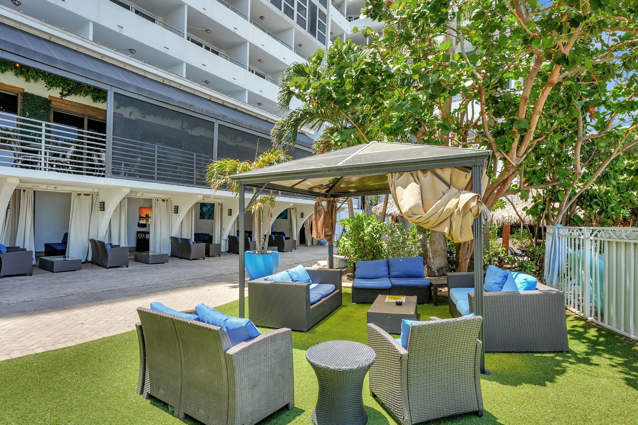 Multiple cabanas lined up near the lawn and pool at Ocean Manor