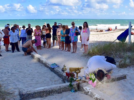 Beach blessing ceremony with the community gathered around the Miracle Cross