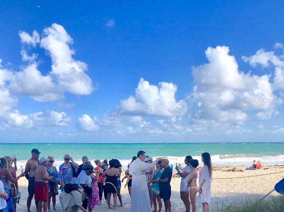 Congregation standing near the Miracle Cross during a shoreline service