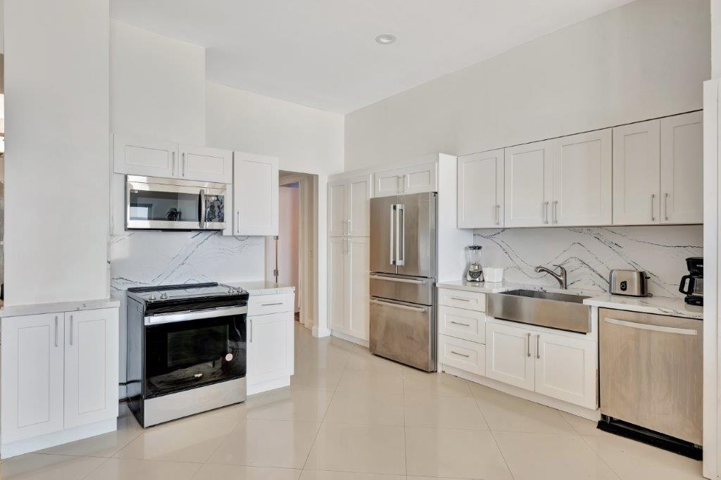 Modern kitchen with white cabinetry and stainless steel appliances