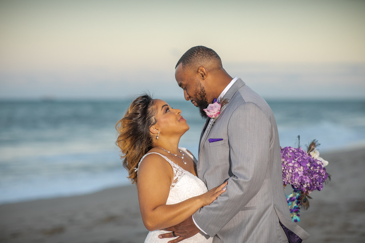 Wedding couple at Ocean Manor with ballroom and ocean views in background