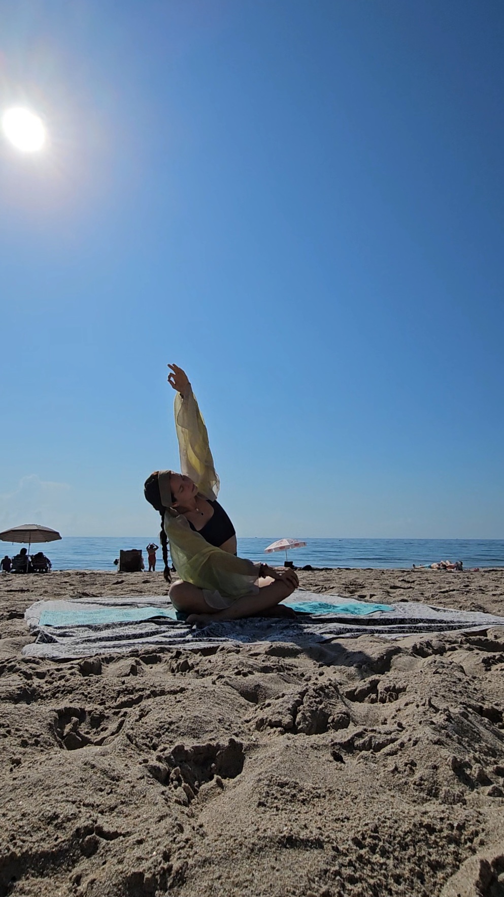 Professional yoga instructor Julia Kornbluh leading beach yoga